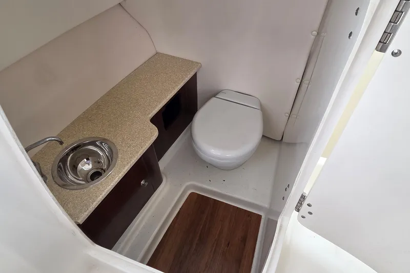 Slide: The Image of 2017 Robalo R247 Dual Console boat bathroom with sink and toilet. - 9