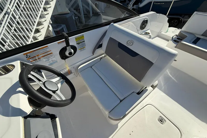 Slide: The Image of 2025 Hurricane SunDeck 235 OB boat interior with steering wheel and seating. - 11