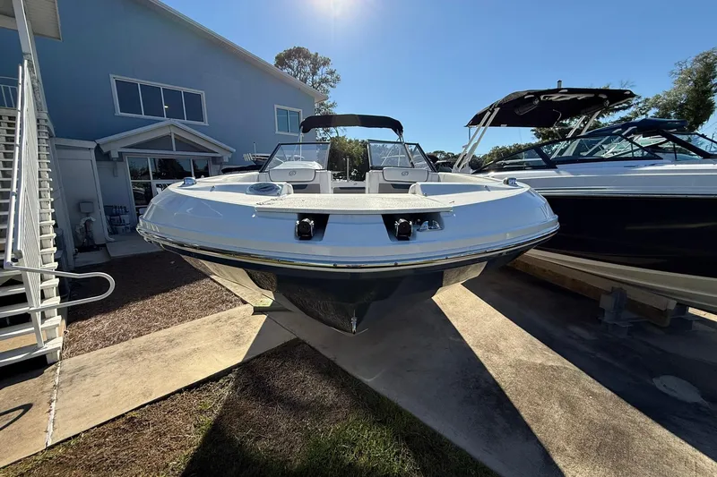 Slide: The Image of 2025 Hurricane SunDeck 235 OB boat displayed outdoors under clear blue sky. - 2
