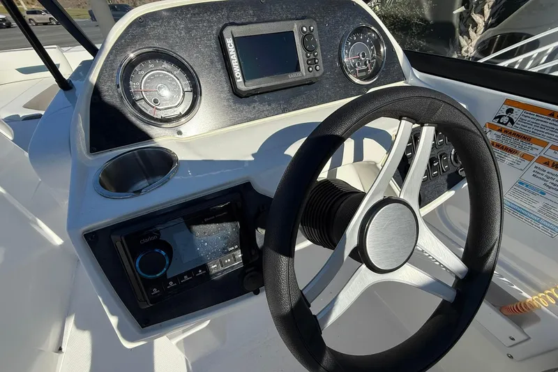 Slide: The Image of 2025 Hurricane SunDeck 235 OB boat dashboard with steering wheel and navigation instruments. - 8