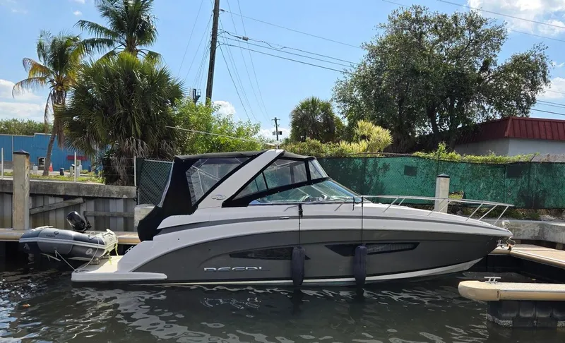 The Image of 2017 Regal 32 Express boat docked near tropical trees and buildings. - 1