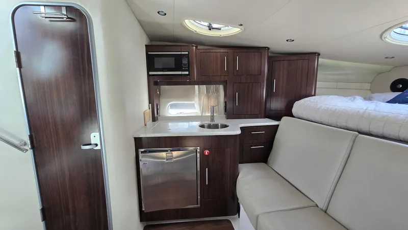 Slide: The Image of 2017 Regal 32 Express interior with kitchenette, seating, and bed. Modern yacht cabin design. - 9