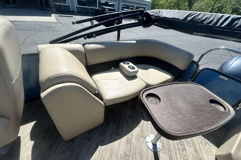 Slide: The Image of 2018 Manitou Aurora LE 22 RF boat interior with beige seating and table. - 10