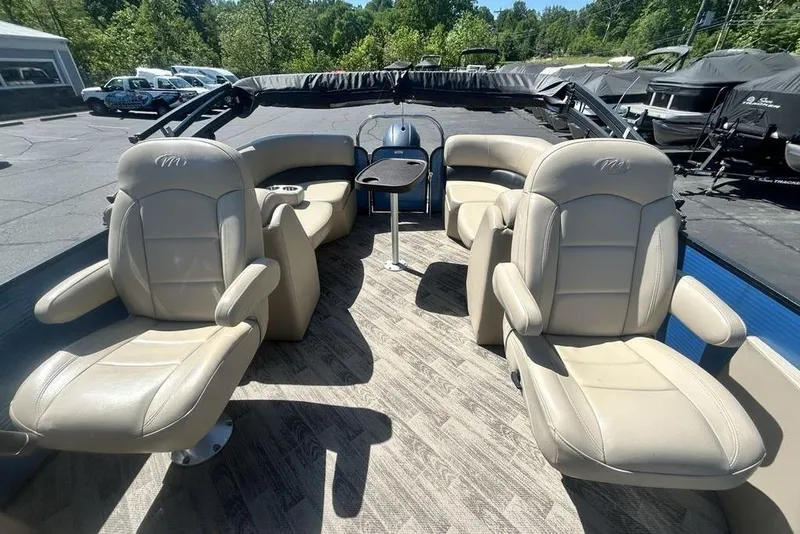 Slide: The Image of 2018 Manitou Aurora LE 22 RF Twin Tube boat interior with beige seating and table. - 4