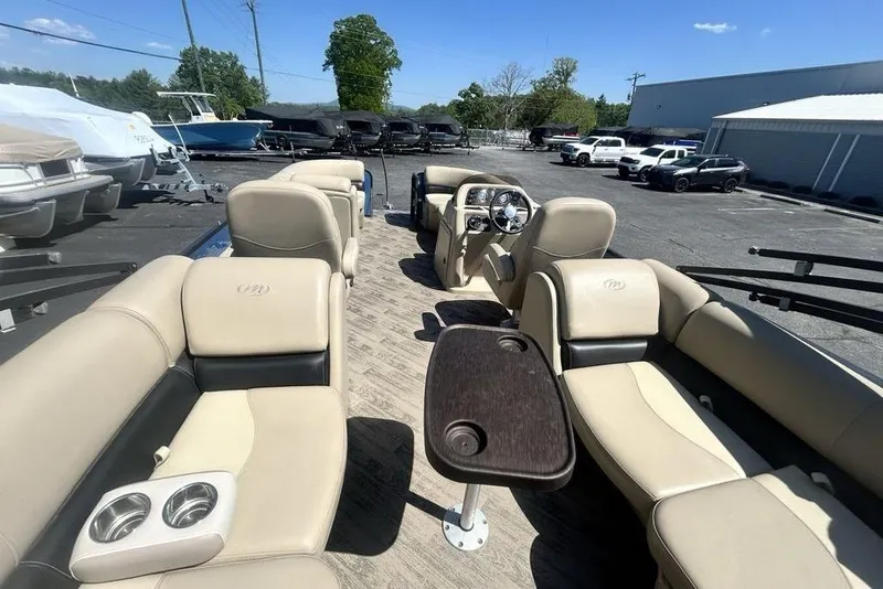 Slide: The Image of 2018 Manitou Aurora LE 22 RF Twin Tube boat interior with beige seating and steering console. - 9