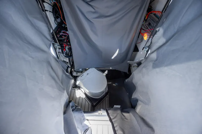 Slide: The Image of Interior view of 2025 Yamaha Boats 255 FSH Sport H, featuring a compact marine toilet. - 16