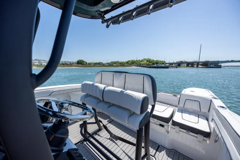 Slide: The Image of 2025 Yamaha Boats 255 FSH Sport H interior with seating, steering wheel, and water view. - 17