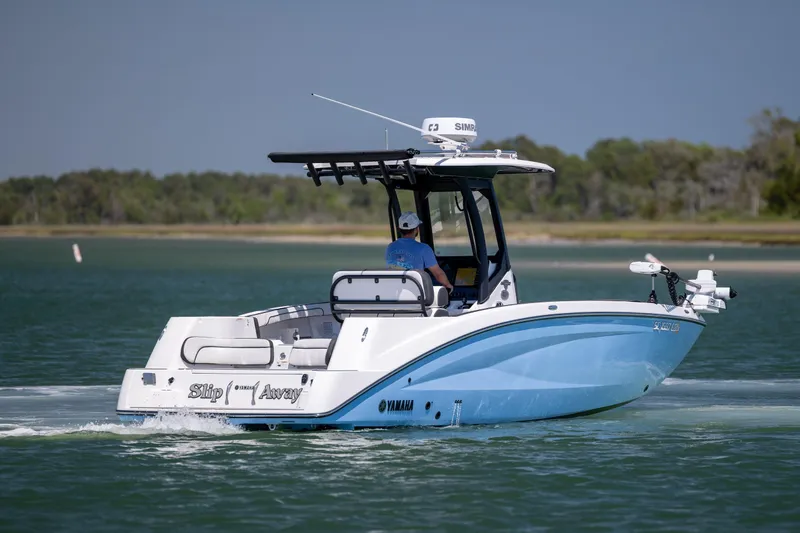 Slide: The Image of 2025 Yamaha Boats 255 FSH Sport H cruising on a serene lake. - 2