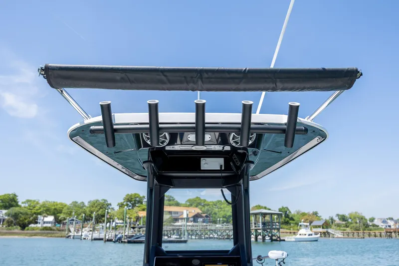 Slide: The Image of 2025 Yamaha Boats 255 FSH Sport H, featuring sleek design and rod holders, docked by the shore. - 30