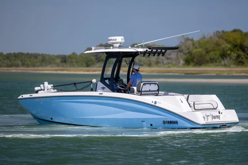 Slide: The Image of 2025 Yamaha Boats 255 FSH Sport H cruising on a serene waterway. - 4