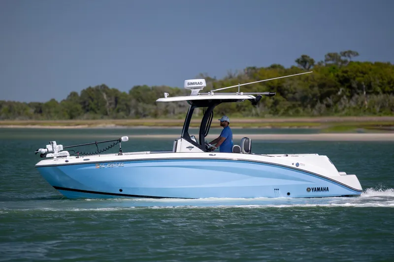 Slide: The Image of 2025 Yamaha Boats 255 FSH Sport H cruising on a serene waterway. - 5