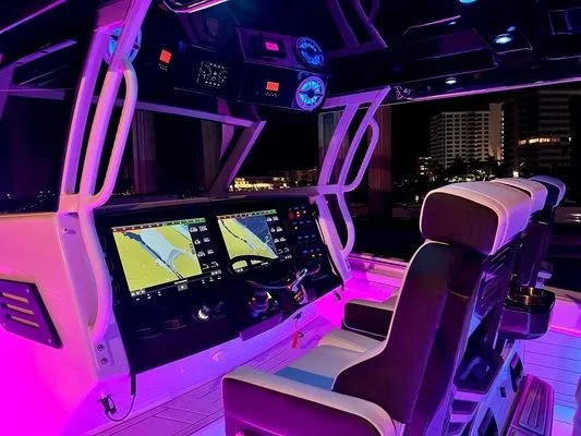 Slide: The Image of 2024 Blackfin 400 CC boat cockpit with illuminated navigation screens and seating. - 11