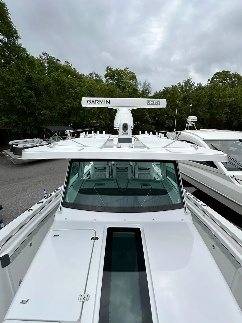 Slide: The Image of 2024 Blackfin 400 CC boat with Garmin radar, docked near trees. - 21