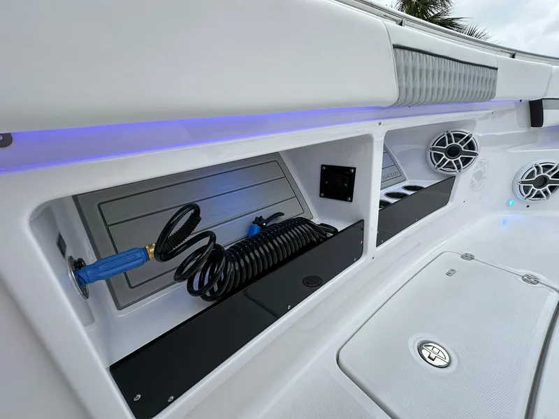 Slide: The Image of 2024 Blackfin 400 CC boat interior with storage compartments and coiled hose. - 22