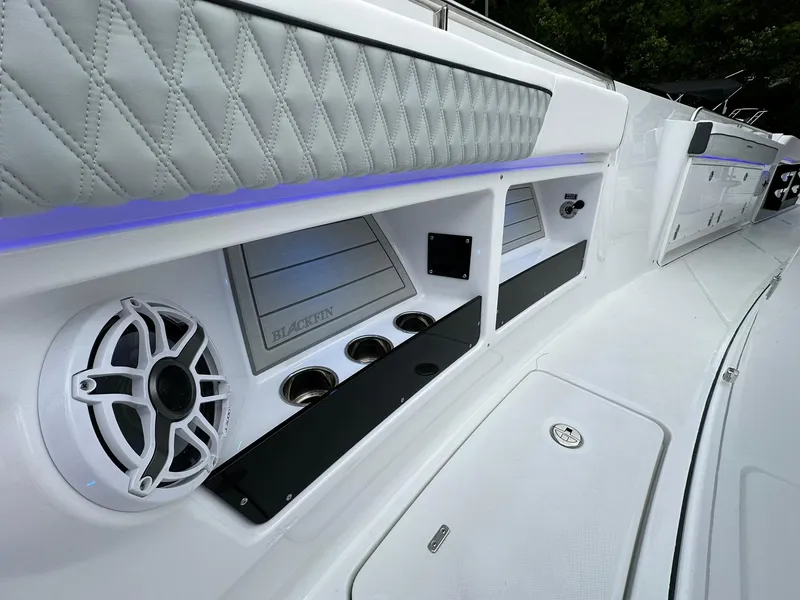 Slide: The Image of 2024 Blackfin 400 CC boat interior with speaker, cup holders, and quilted upholstery. - 30