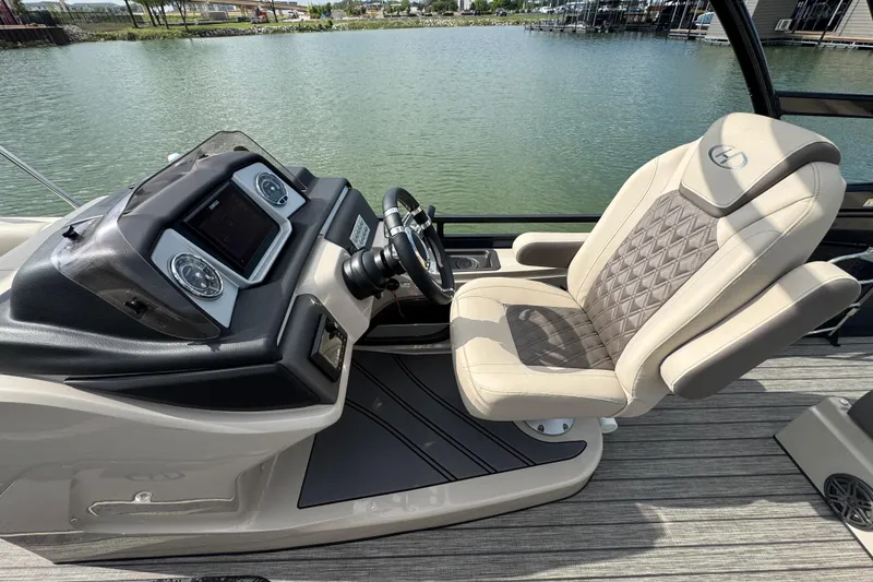 Slide: The Image of Captain's seat and helm of 2021 Harris Solstice 230 boat on a lake. - 11