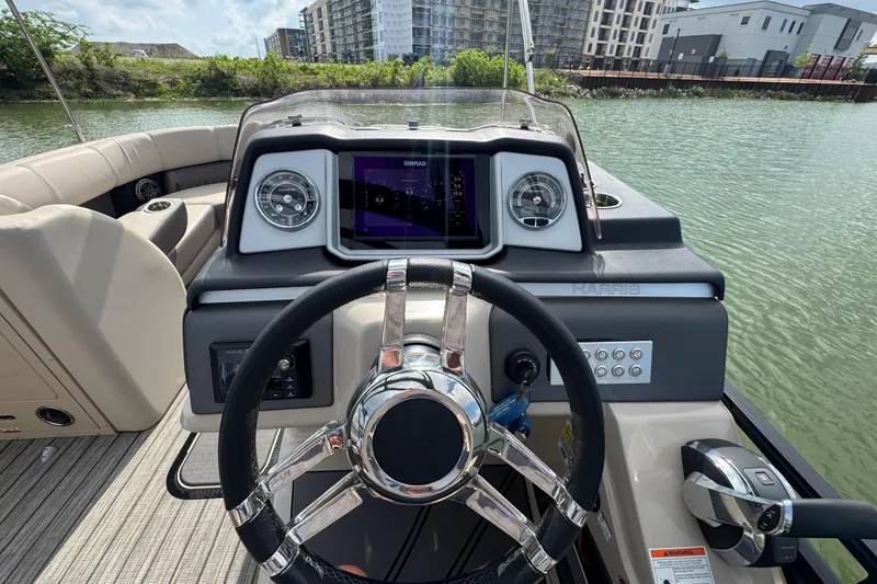 Slide: The Image of 2021 Harris Solstice 230 boat dashboard with steering wheel and navigation display. - 13