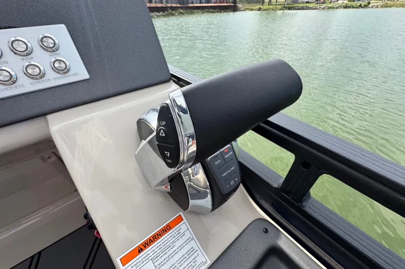 Slide: The Image of Throttle control panel on a 2021 Harris Solstice 230 boat, near water. - 18