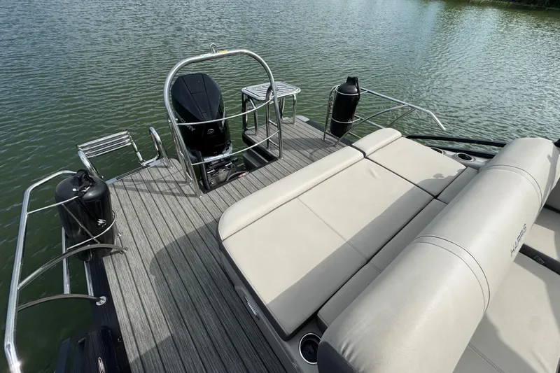 Slide: The Image of 2021 Harris Solstice 230 boat with spacious deck and comfortable seating on water. - 22