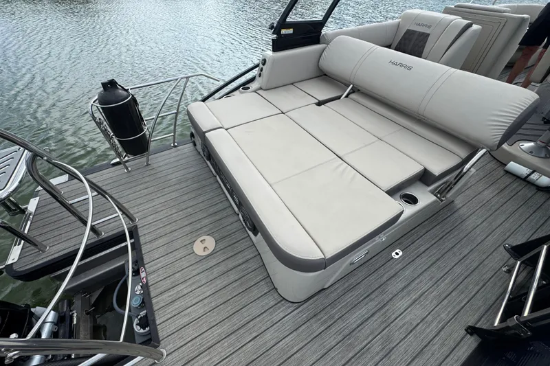Slide: The Image of 2021 Harris Solstice 230 boat with spacious seating on a sleek deck by the water. - 24