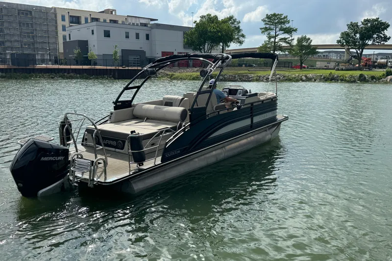 Slide: The Image of 2021 Harris Solstice 230 pontoon boat on a calm river near urban buildings. - 4