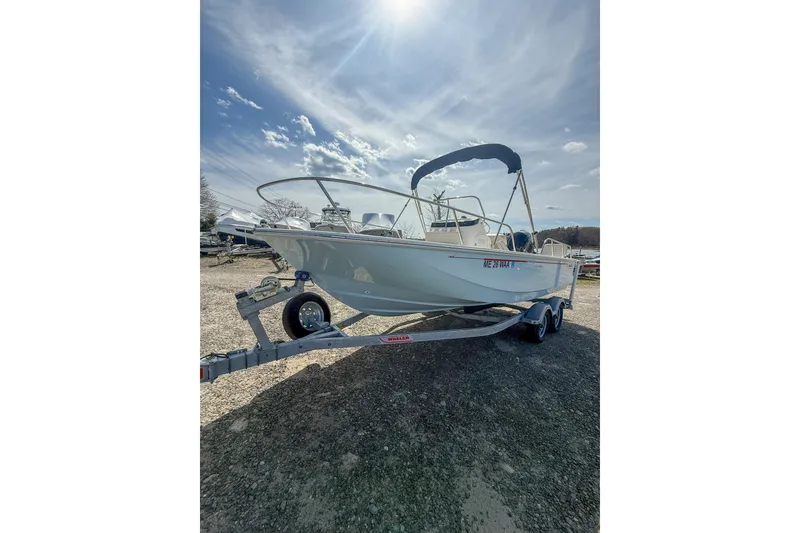 Slide: The Image of 2025 Boston Whaler 190 Montauk boat on trailer under sunny sky. - 2