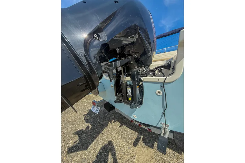 Slide: The Image of 2025 Boston Whaler 190 Montauk boat engine detail under clear blue sky. - 5