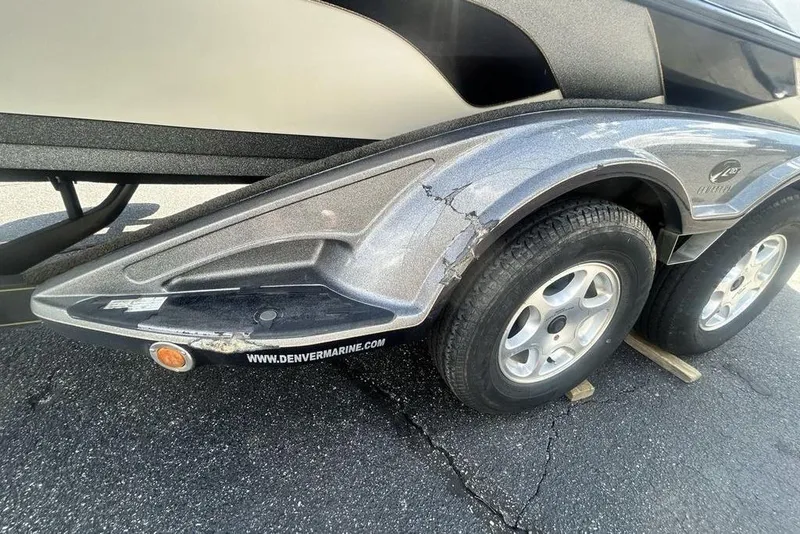 Slide: The Image of 2007 Ranger Z20 boat trailer with visible wear and dual wheels on asphalt. - 21