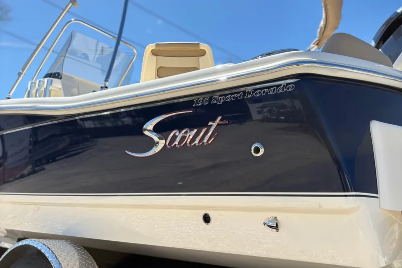 Slide: The Image of 2024 Scout 195 Sport Dorado boat, sleek design, navy and white exterior. - 3