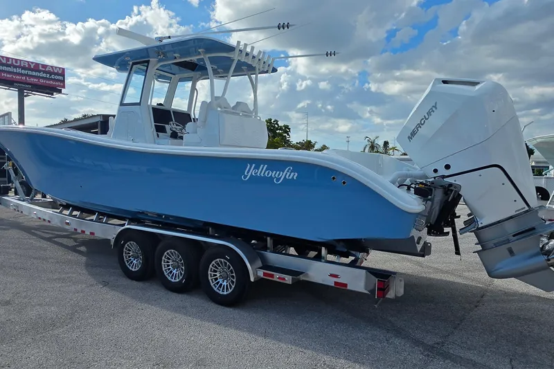 Slide: The Image of 2026 Yellowfin 36 Offshore boat on trailer with Mercury engine, under a cloudy sky. - 6