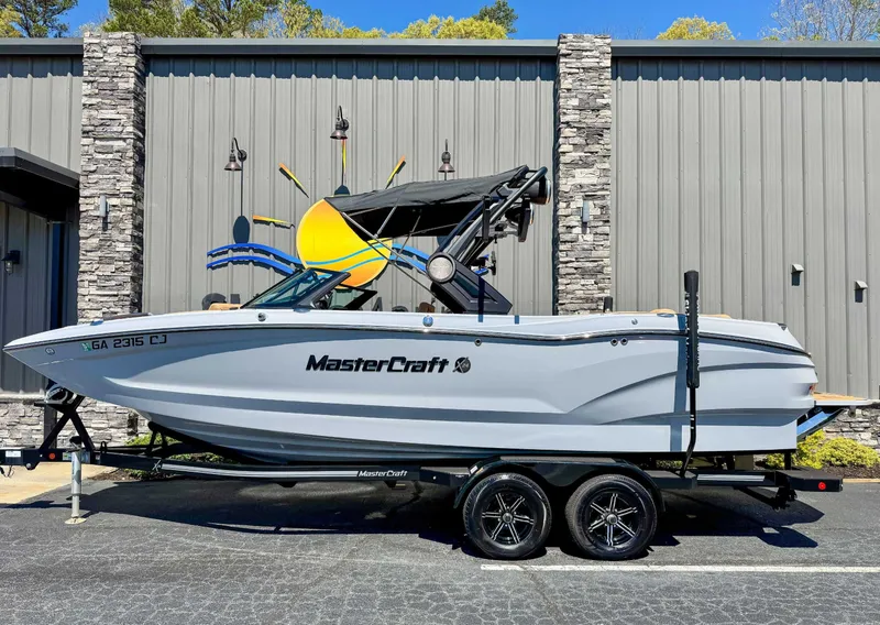 The Image of 2024 MasterCraft X24 boat on trailer in front of building. - 1