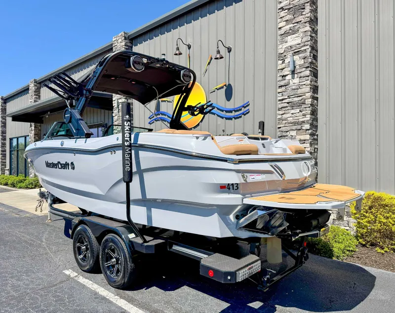 Slide: The Image of 2024 MasterCraft X24 boat on trailer in front of building. - 7