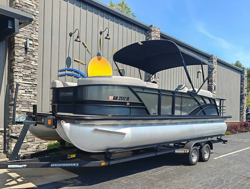 Slide: The Image of 2023 Sylvan L-3 CLZ DH pontoon boat on trailer outside building. - 3