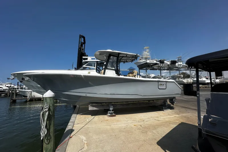The Image of 2018 Sea Hunt Gamefish 27 boat docked at marina under clear blue sky. - 1