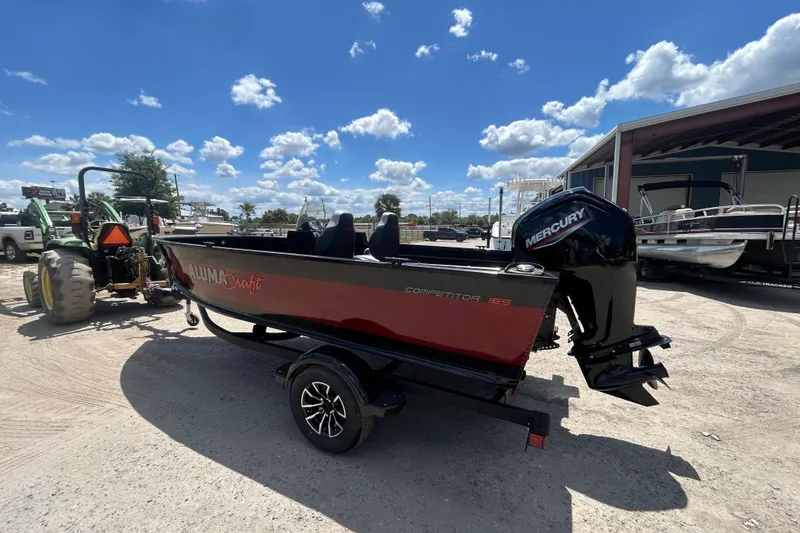 Slide: The Image of 2023 Competitor 165 SC boat with Mercury engine on trailer, parked outdoors. - 12