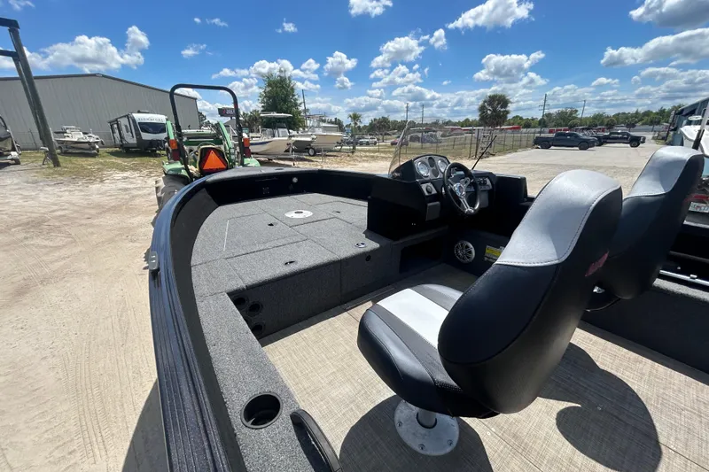 Slide: The Image of 2023 Competitor 165 SC boat interior with steering console and seating under a sunny sky. - 13