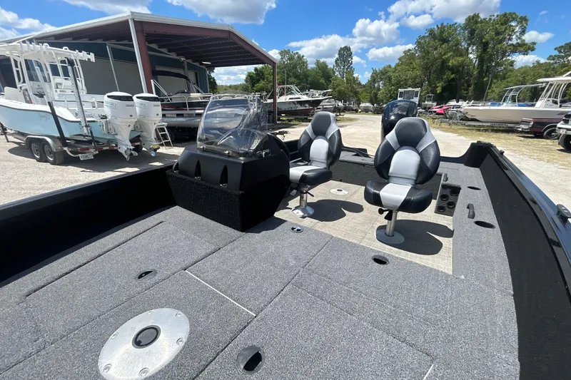 Slide: The Image of 2023 Competitor 165 SC boat interior with dual seats and console, parked outdoors. - 17