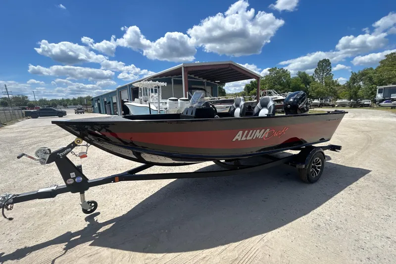 Slide: The Image of 2023 Alumacraft Competitor 165 SC boat on trailer under blue sky. - 18
