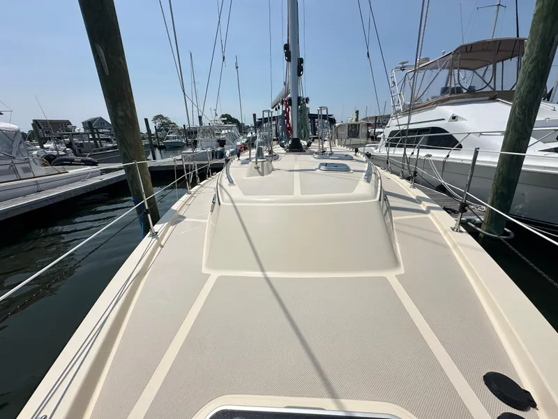 Slide: The Image of 2021 Island Packet 439 sailboat docked at marina, showcasing spacious deck and rigging. - 10