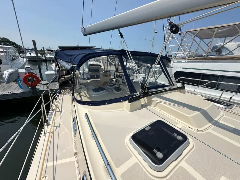 Slide: The Image of 2021 Island Packet 439 sailboat docked, featuring a sleek deck and blue canopy. - 15
