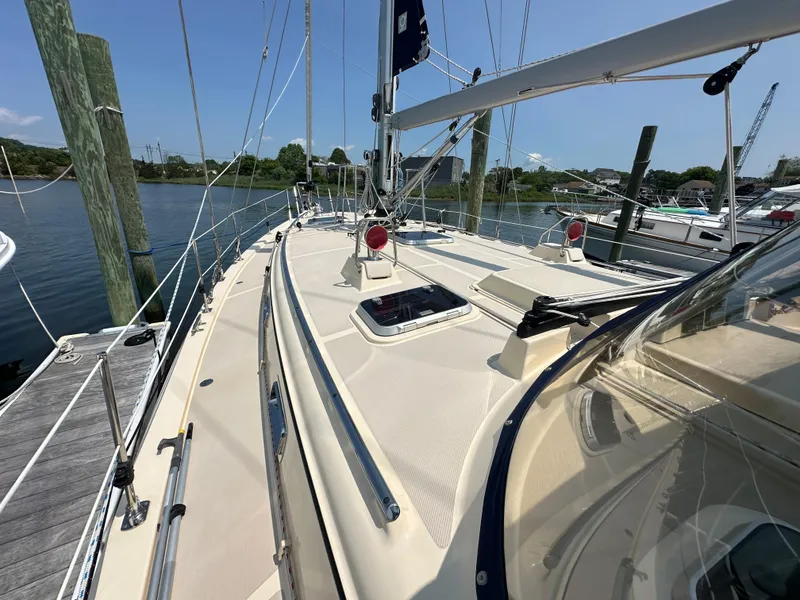 Slide: The Image of 2021 Island Packet 439 sailboat docked, showcasing deck and rigging under clear skies. - 6