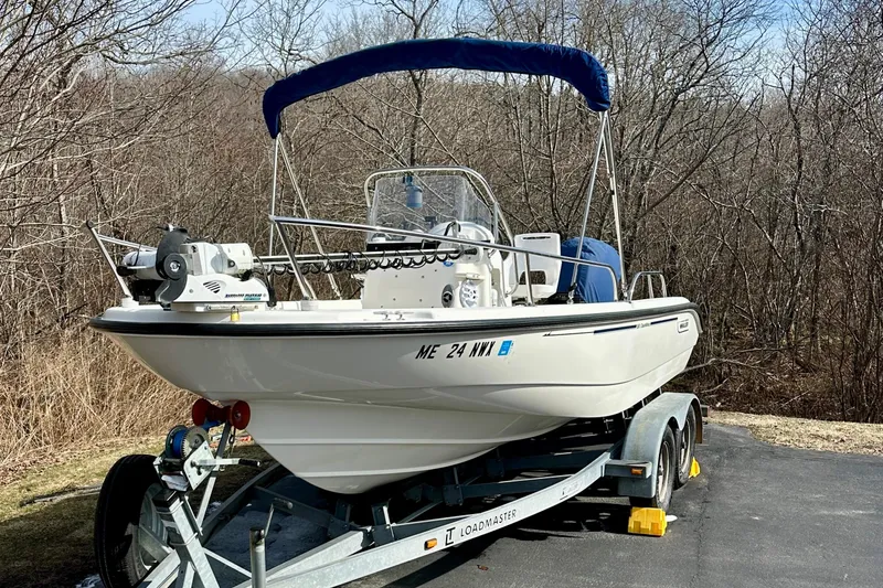 Slide: The Image of 2005 Boston Whaler DAUNTLESS 180 boat on trailer, parked outdoors with trees in background. - 6