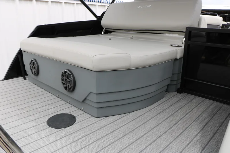 Slide: The Image of 2026 Sylvan Mirage Cruise 8520 CLZ DH boat interior with cushioned seating and speakers. - 21