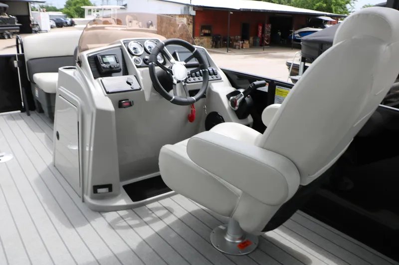 Slide: The Image of 2026 Sylvan Mirage Cruise 8520 CLZ DH boat interior with steering console and captain's chair. - 24