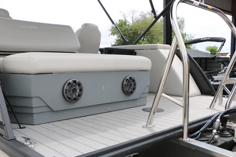 Slide: The Image of 2026 Sylvan Mirage Cruise 8520 CLZ DH boat interior with cushioned seating and speakers. - 8
