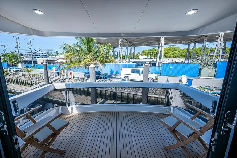 Slide: The Image of Deck view from 2026 Maritimo M50 yacht, featuring wooden flooring and outdoor seating. - 85