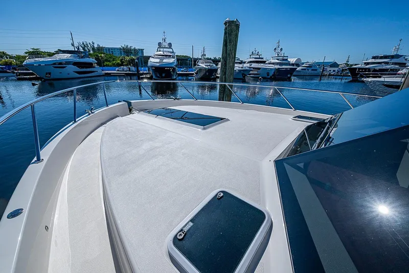 Slide: The Image of Bow view of 2026 Maritimo M50 yacht docked in a marina under clear blue skies. - 87