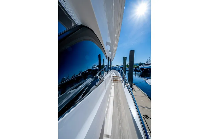 Slide: The Image of 2026 Maritimo M50 yacht docked under bright sun, showcasing sleek design and reflective windows. - 89