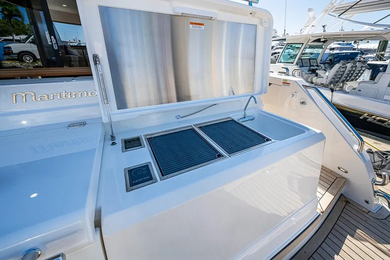 Slide: The Image of Open storage compartment on 2026 Maritimo M50 yacht deck with wooden and metal finishes. - 93
