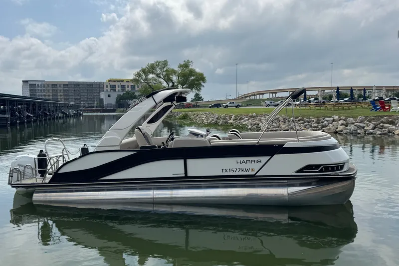 Slide: The Image of 2023 Harris Grand Mariner 250 pontoon boat on calm water, with modern design and sleek features. - 6